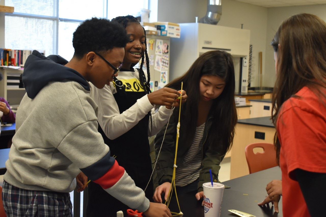 Students building pasta tower - team building activity. Students building pasta tower - team building activity.